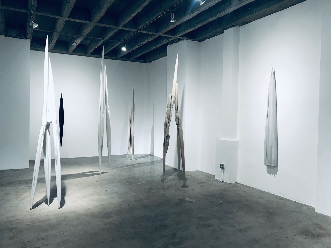 Gallery exhibition with hanging sculptural works